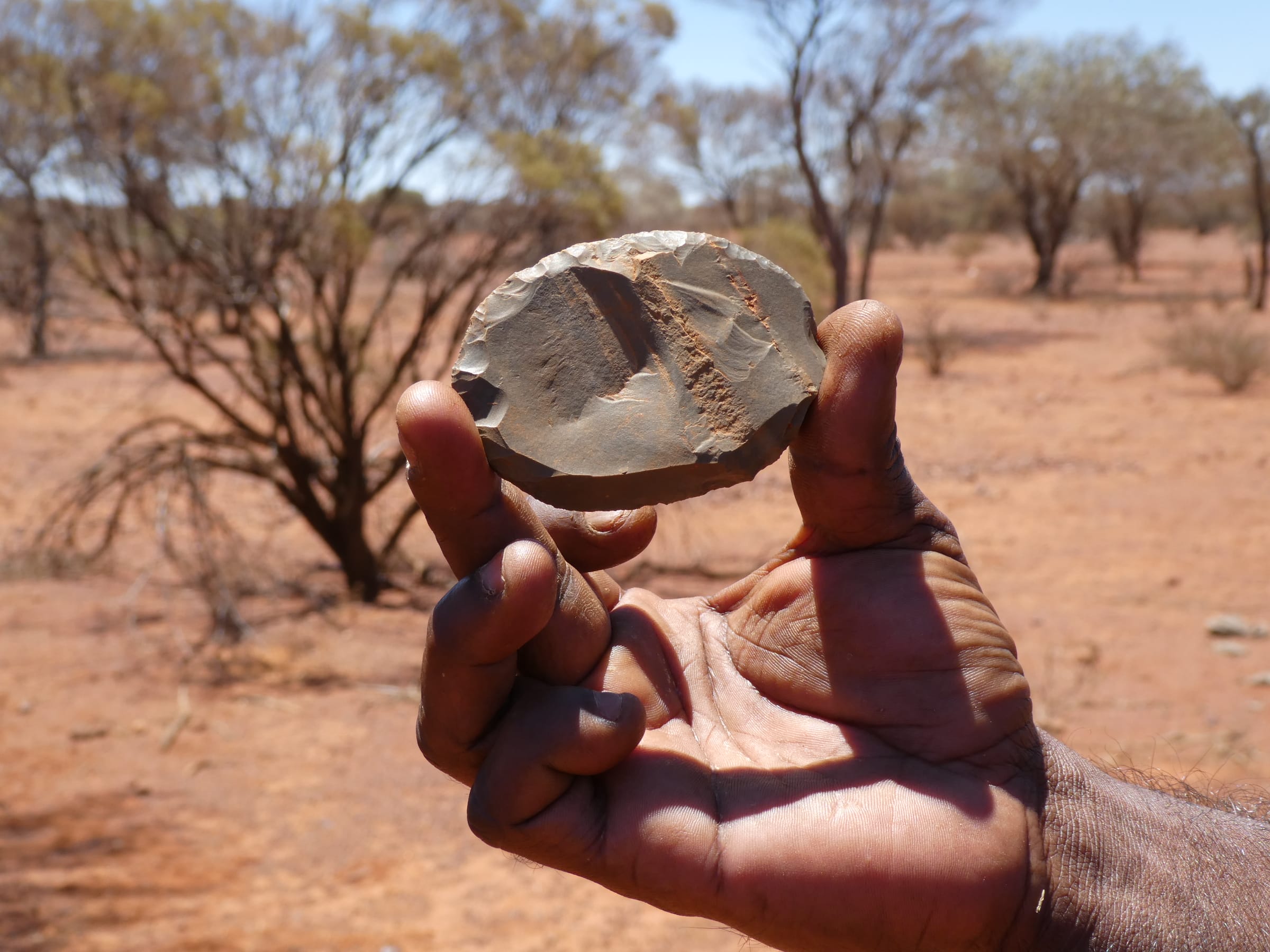 echoes team member holding a rock with sharpened edge