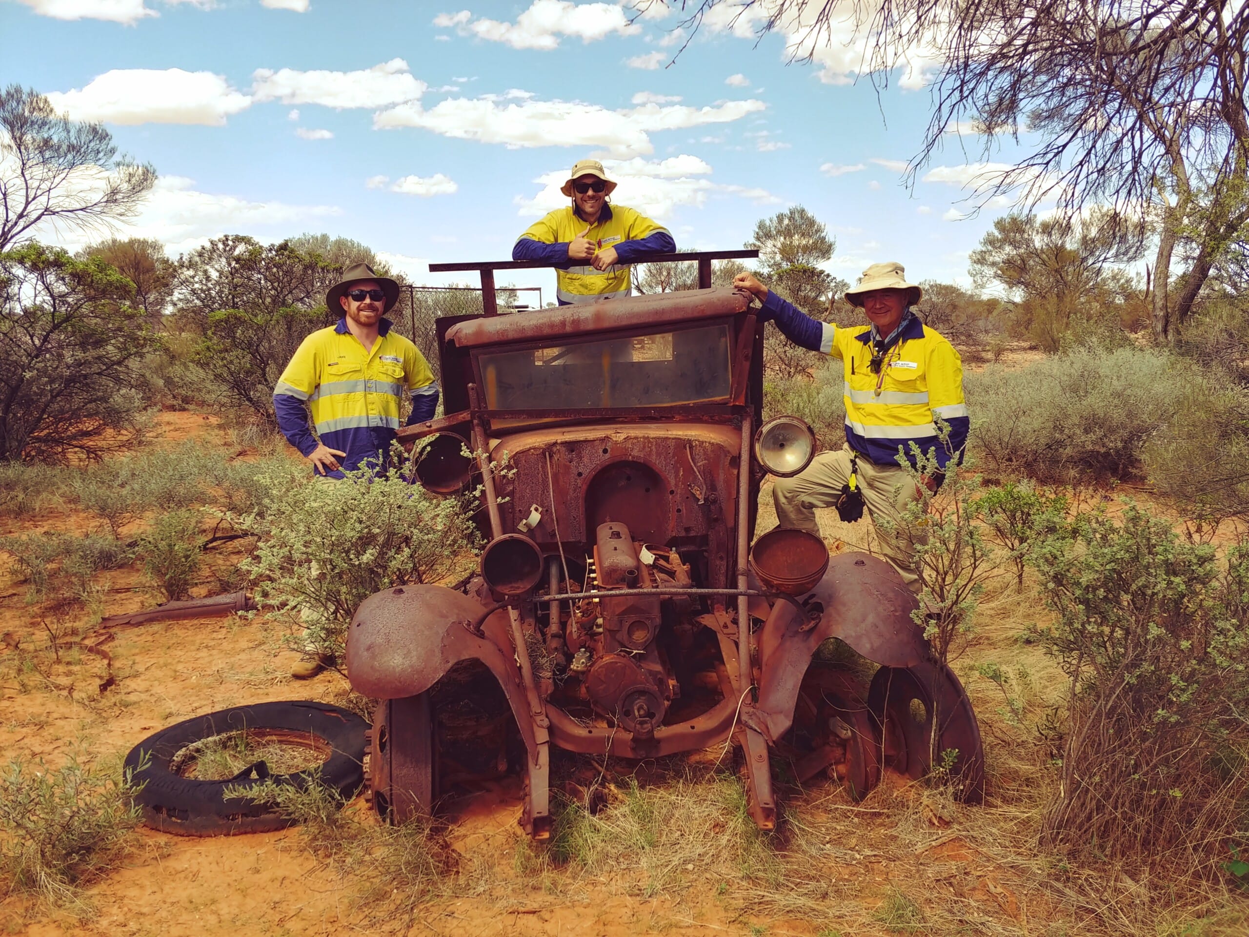 old dilapidated automobile in the middle of a shrubland